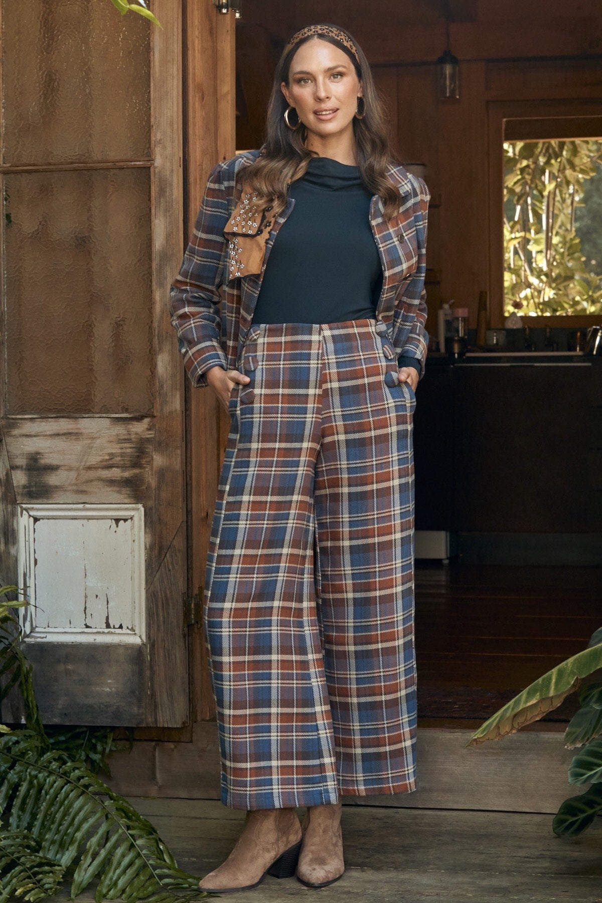 Fashion model in a relaxed pose, wearing a floral print dress.