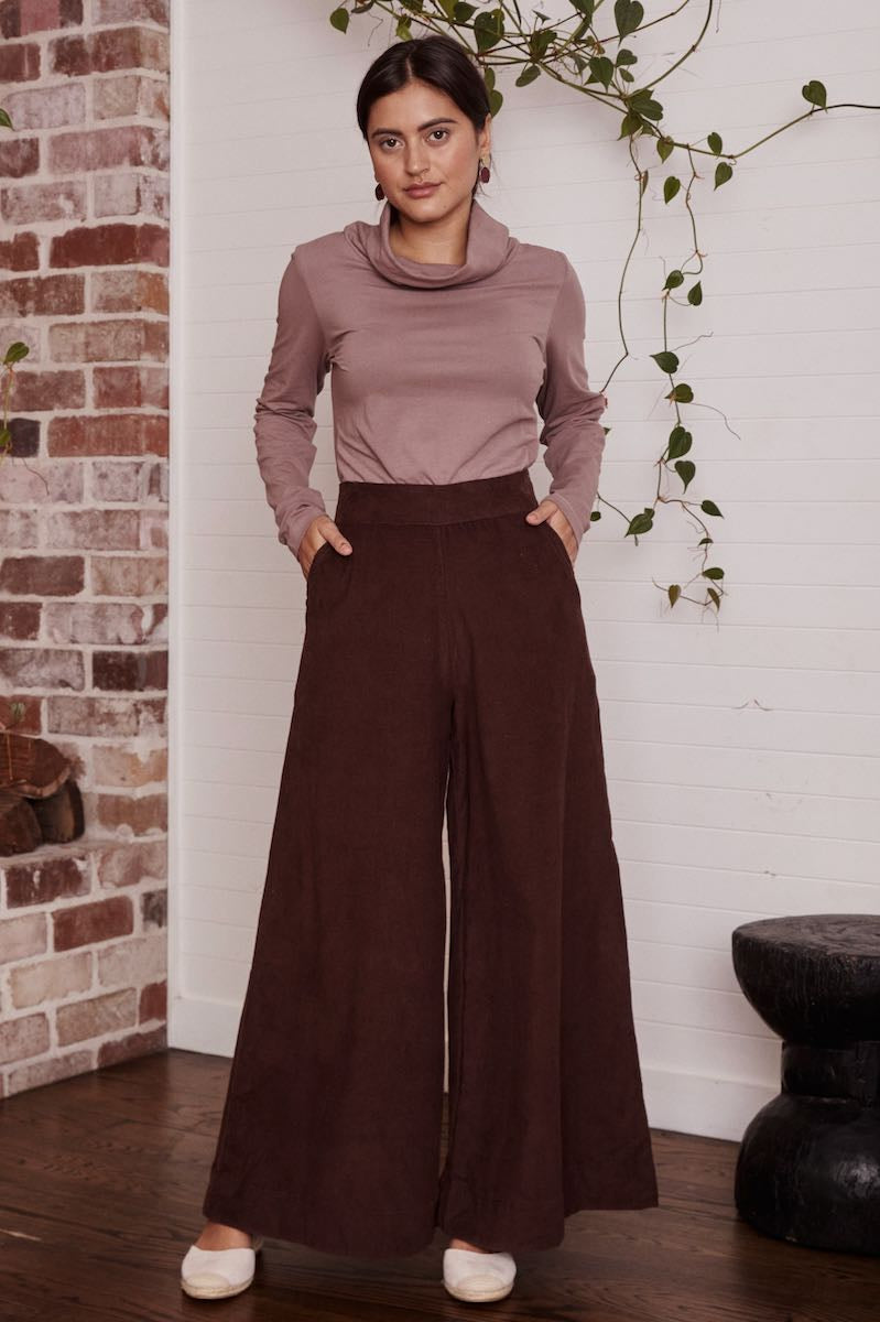 A lovely, patterned dress laid out flat, the intricate details and rich texture of the fabric on full display.
