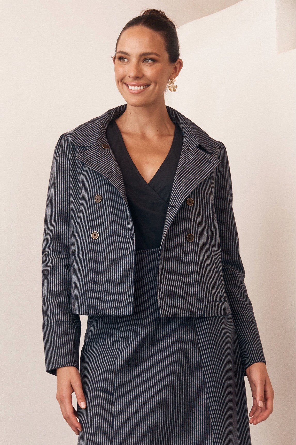 Woman wearing a tartan print outfit, standing outdoors in a relaxed pose.