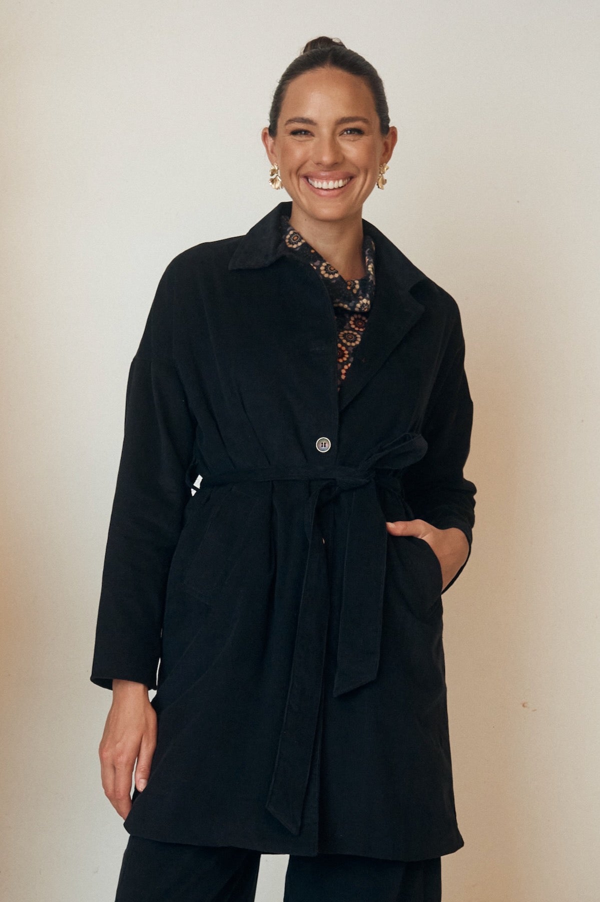 Close-up of a floral dress with flowing sleeves, displayed on a hanger.