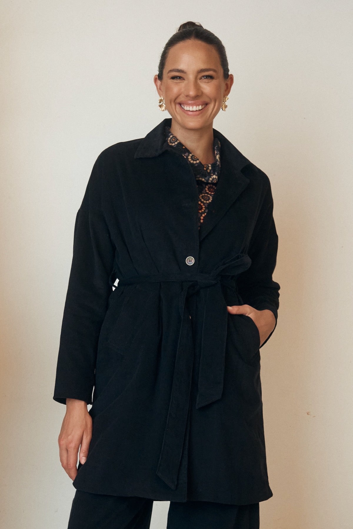 Close-up of a floral dress with flowing sleeves, displayed on a hanger.