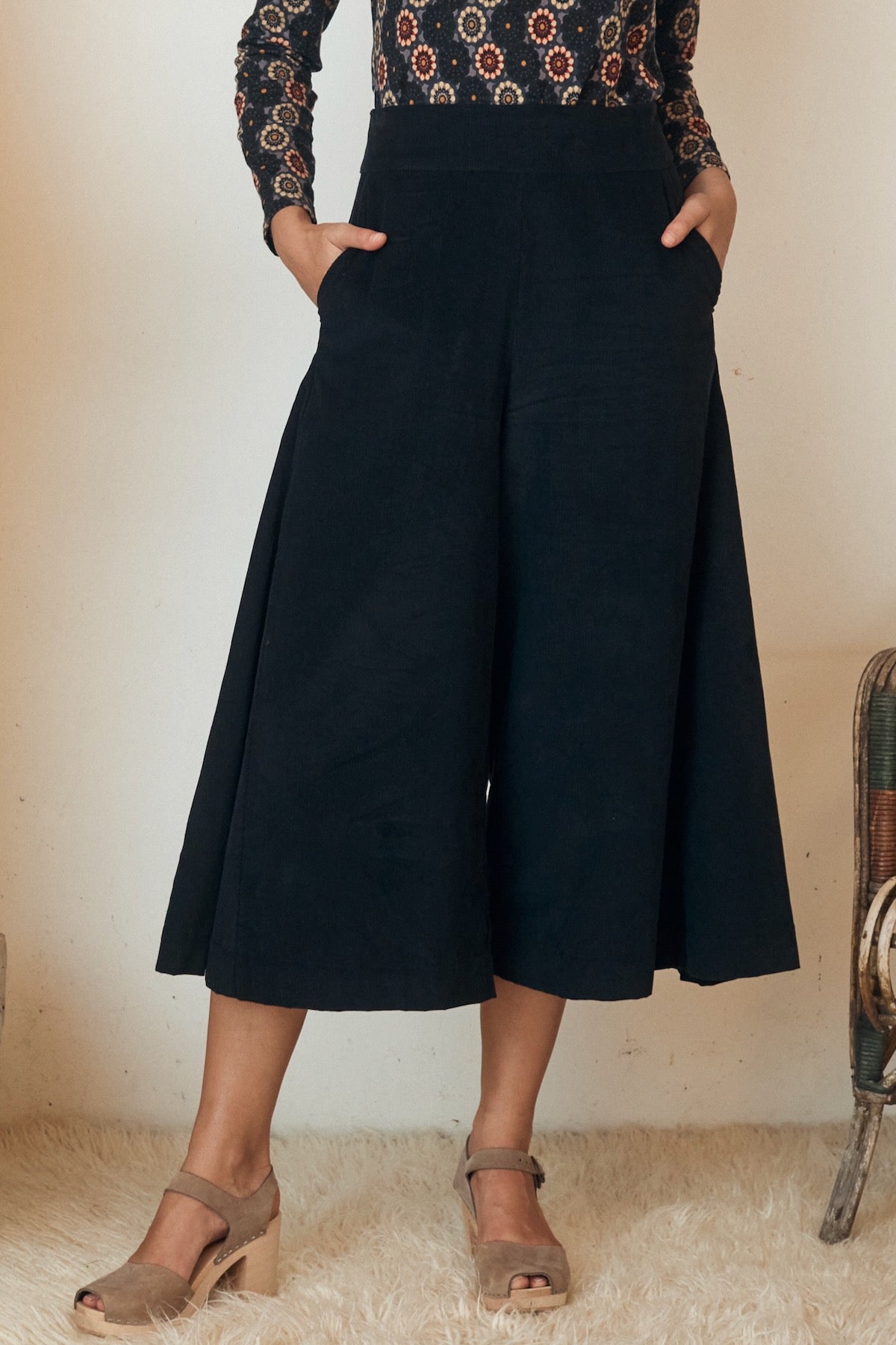 Close-up of a woman wearing a floral dress with a flared hem and gathered waist.