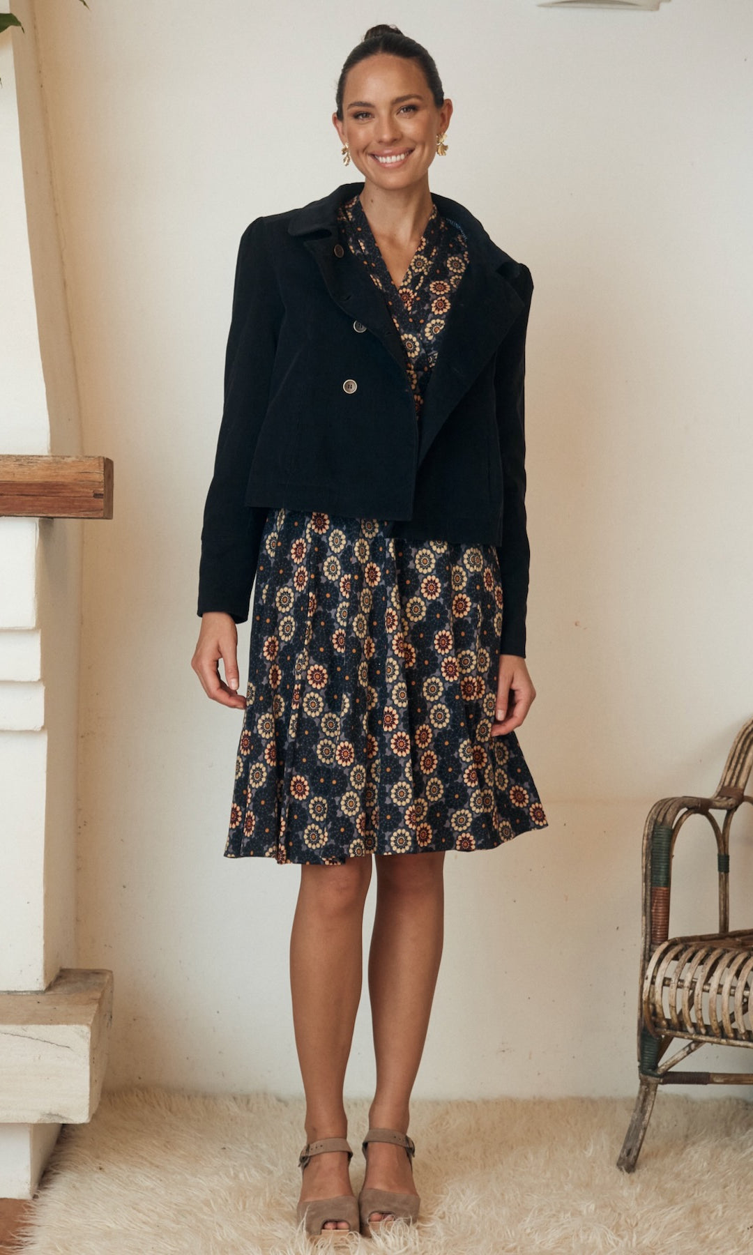 A chic, summer dress in a relaxed, breezy style displayed against a warm, inviting backdrop.